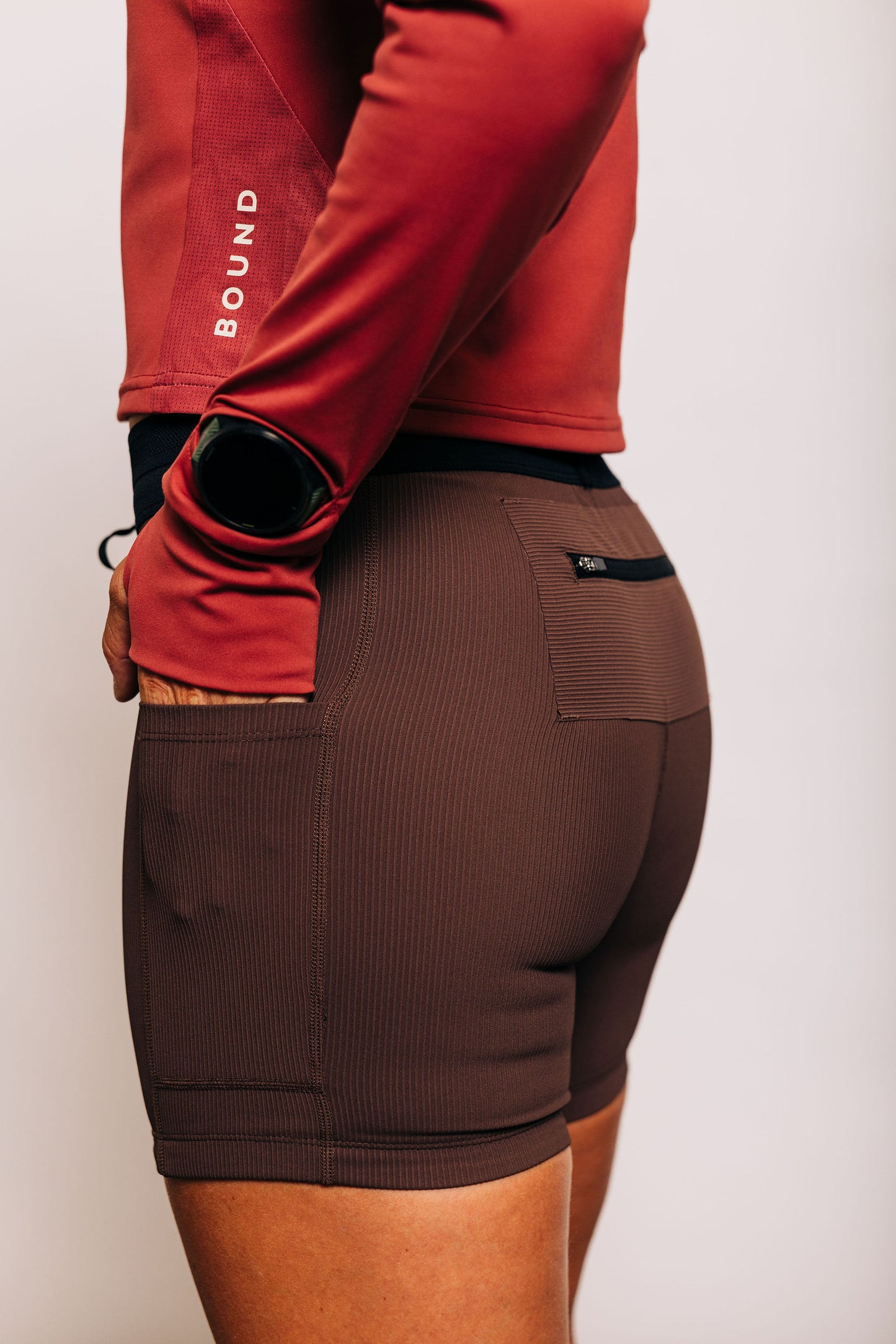 Back three-quarter view showing the zippered back pocket on the Coffee Bean tight