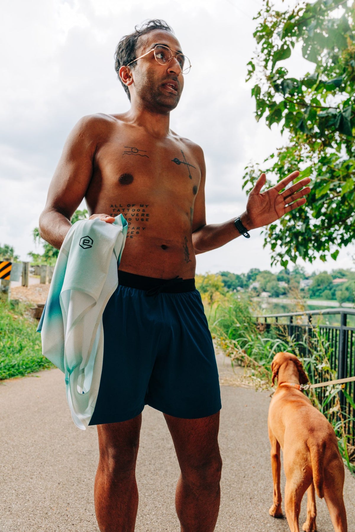 A runner chatting after a run, with his dog beside him